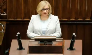Kobieta w jasnej marynarce przemawia w sejmie, dyskutując o wpływie polityki PiS na prawa kobiet w Polsce.