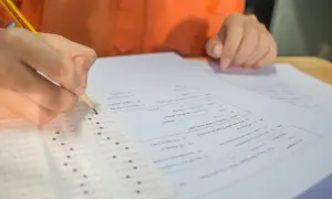 Ręka z ołówkiem zaznacza odpowiedzi na arkuszu testowym. Zastanawiasz się, ile punktów na maturze z matematyki zdobędziesz?