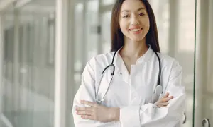 Uśmiechnięta lekarka w białym kitlu ze stetoskopem. Zastanawiasz się, ile zarabia lekarz?