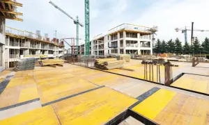 Budowa osiedla w ramach programu mieszkaniowego lewicy: budownictwo społeczne zamiast kredytów. Dźwigi i materiały budowlane na placu budowy.