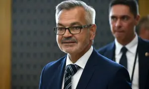 Mężczyzna w okularach, w granatowym garniturze i krawacie, przypomina ambasadora Rosji.
