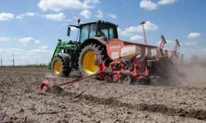 Traktor sieje na polu. Koalicja Obywatelska obietnice dla rolników a rzeczywistość – ciężka praca na roli trwa.
