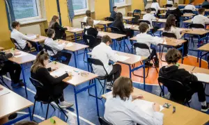 Uczniowie w skupieniu piszą egzaminy ósmoklasisty w sali gimnastycznej. Cisza i powaga towarzyszą temu ważnemu dniu.