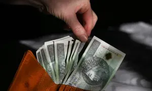 Dłoń wyciąga banknot 100 zł z brązowego portfela. Czy trzynasta i czternasta emerytura to pomysł PiS?