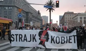 Protest Strajku Kobiet na ulicach Warszawy. Uczestnicy niosą transparent "STRAJK KOBIET". Jak protesty strajku kobiet wpłynęły na poparcie PiS?