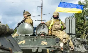 Żołnierze na transporterze z flagą Ukrainy. To obrazuje stosunek Konfederacji do wojny na Ukrainie i pomocy uchodźcom.