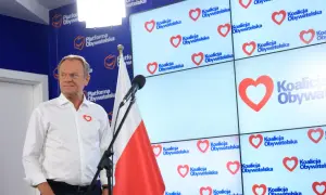 Donald Tusk prezentuje, co Koalicja Obywatelska proponuje dla nauczycieli i edukacji. Na ekranach logo partii z sercem.