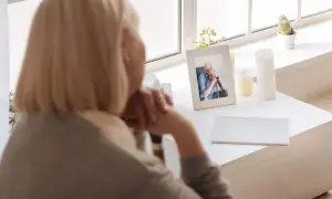 Kobieta patrzy na zdjęcie zmarłego męża. Czy renta wdowia komu dokładnie przysługuje z projektu lewicy?