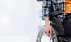 Osoba na wózku inwalidzkim zastanawia się, ile wynosi renta socjalna.