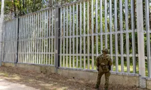Strażnik graniczny przy płocie z drutem kolczastym. Nowa polityka migracyjna rządu koalicji obywatelskiej na granicy z Białorusią.