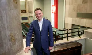 Szymon Hołownia jako Marszałek Sejmu: ocena jego kadencji i potencjalne wpadki. Uśmiechnięty polityk w garniturze na tle sali sejmowej.