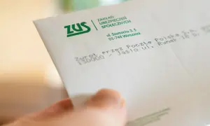 Dłoń trzyma dokument ZUS. Konfederacja i dobrowolny ZUS dla firm – dokładne kalkulacje są kluczowe dla przedsiębiorców.