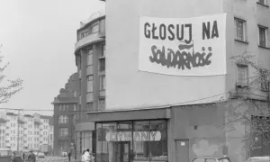 Transparent baner "Głosuj na Solidarność" na budynku, symboliczny protest przeciwko komunizmowi.
