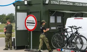Strażnicy graniczni prowadzą kontrole na granicy niemieckiej. Obok zielonego punktu kontrolnego stoją dwa rowery na bagażniku samochodu.