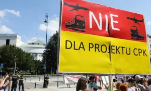 Protestujący sprzeciwiają się projektowi CPK. Transparent "NIE DLA PROJEKTU CPK" z symbolami samolotu i pociągu.