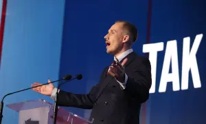 Poseł Konfederacji z mównicą, gestykuluje, mówiąc o bonie zdrowotnym.