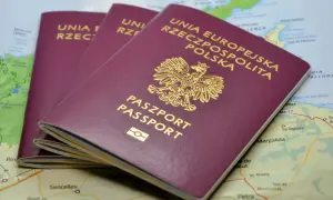 Trzy polskie paszporty leżą na mapie. Zastanawiasz się, ile się czeka na paszport?
