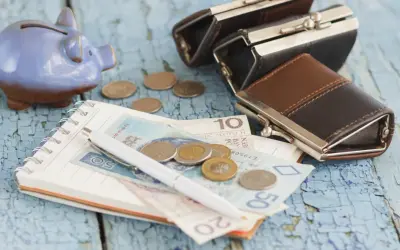 Świnka-skarbonka, portmonetki, notatnik z pieniędzmi i monetami. Zastanawiasz się, ile wynosi zasiłek dla bezrobotnych?
