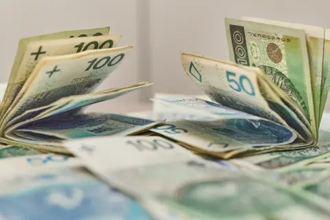 Pieniądze, banknoty 100 i 50 zł, leżące na stole. Może to być dodatek aktywizacyjny dla pracowników.