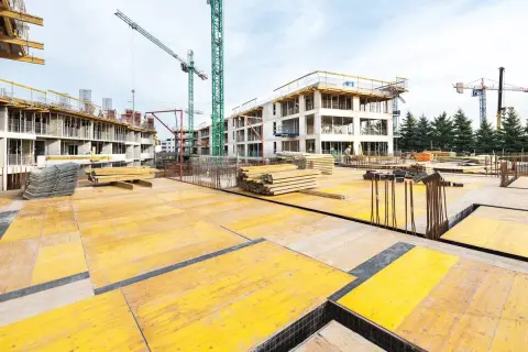 Budowa osiedla w ramach programu mieszkaniowego lewicy: budownictwo społeczne zamiast kredytów. Dźwigi i materiały budowlane na placu budowy.