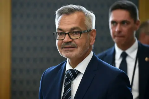 Mężczyzna w okularach, w granatowym garniturze i krawacie, przypomina ambasadora Rosji.