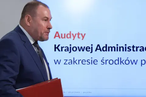 Audyty w ministerstwach po rządach PiS, wyniki Koalicji Obywatelskiej. Mężczyzna w garniturze prezentuje wyniki kontroli.