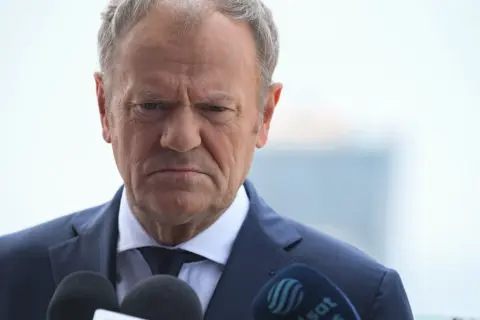 Donald Tusk z zaciętą miną przed mikrofonami. Czy Koalicja Obywatelska rozliczy afery PiS?