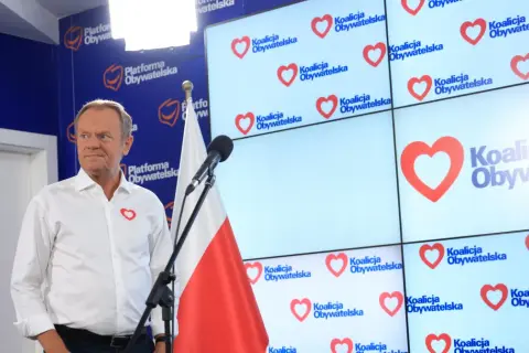 Donald Tusk prezentuje, co Koalicja Obywatelska proponuje dla nauczycieli i edukacji. Na ekranach logo partii z sercem.