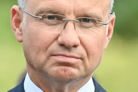 Zbliżenie na twarz mężczyzny w okularach. W jego oczach widać refleksję, jakby zastanawiał się nad przyszłością, może nad swoją emeryturą prezydencką.