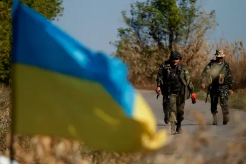 Ukraińska flaga na pierwszym planie, za nią dwaj żołnierze idący drogą. Hasło "stop ukrainizacji Polski" budziło kontrowersje, a Konfederacja używała go w swojej retoryce.