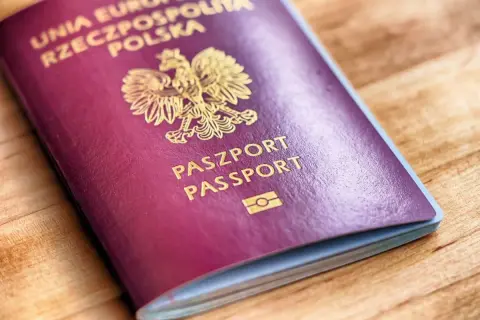 Polski paszport biometryczny z godłem orła i napisem "PASZPORT PASSPORT" na bordowej okładce.