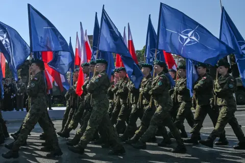 Żołnierze maszerują z flagami NATO i Polski. To obraz polityki obronnej koalicji obywatelskiej, która stawia na zakupy sprzętu wojskowego.