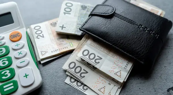 Portfel z pieniędzmi i kalkulatorem. Konfederacja proponuje całkowitą likwidację podatku PIT i CIT, co wiąże się z kosztami dla państwa.