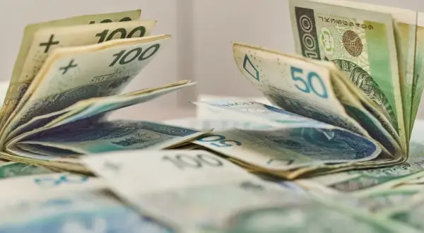 Pieniądze, banknoty 100 i 50 zł, leżące na stole. Może to być dodatek aktywizacyjny dla pracowników.