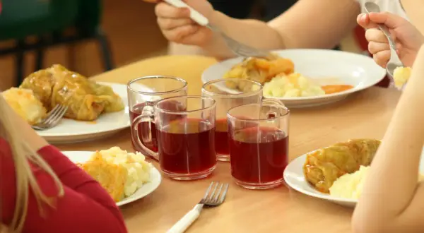 Dzieci jedzą bezpłatne posiłki w szkole. Koszty programu lewicy obejmują takie obiady, jak gołąbki z ziemniakami i kompot.