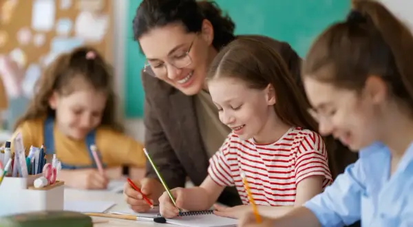 Nauczycielka wspiera uczennice w nauce. Ministerstwo edukacji w rękach Koalicji Obywatelskiej to szansa na likwidację prac domowych i więcej radości z nauki.