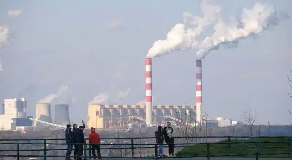 Dymiące kominy elektrowni. Polska 2050: transformacja węglowa koszty i terminy. Ludzie obserwują przemysł.
