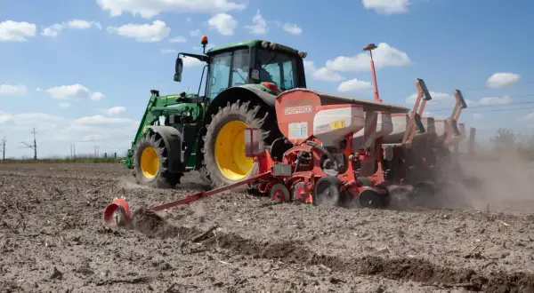 Traktor sieje na polu. Koalicja Obywatelska obietnice dla rolników a rzeczywistość – ciężka praca na roli trwa.