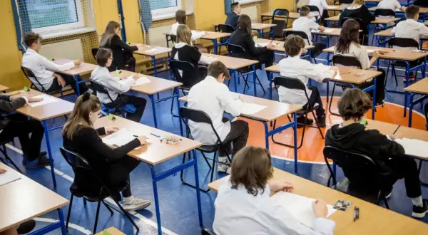 Uczniowie w skupieniu piszą egzaminy ósmoklasisty w sali gimnastycznej. Cisza i powaga towarzyszą temu ważnemu dniu.