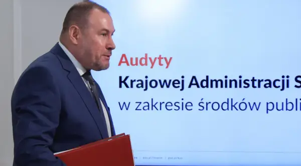 Audyty w ministerstwach po rządach PiS, wyniki Koalicji Obywatelskiej. Mężczyzna w garniturze prezentuje wyniki kontroli.