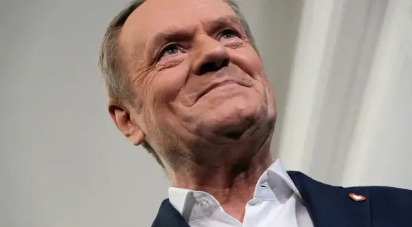 Uśmiechnięty Donald Tusk, jak polityka rządu Tuska wpływa na giełdę i rynek kapitałowy.