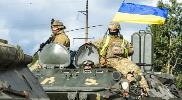 Żołnierze na transporterze z flagą Ukrainy. To obrazuje stosunek Konfederacji do wojny na Ukrainie i pomocy uchodźcom.