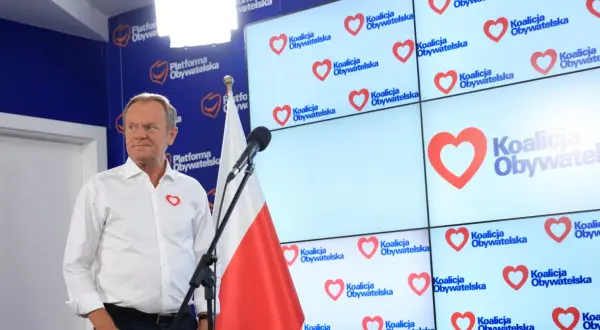Donald Tusk prezentuje, co Koalicja Obywatelska proponuje dla nauczycieli i edukacji. Na ekranach logo partii z sercem.