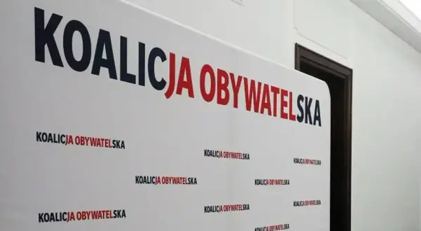 Białe tło z napisem "KOALICJA OBYWATELSKA" w dużych, czerwono-granatowych literach. Pod spodem powtarza się mniejszy napis. To symboliczne tło dla dyskusji o stosunku Koalicji Obywatelskiej do Europejskiego Zielonego Ładu.