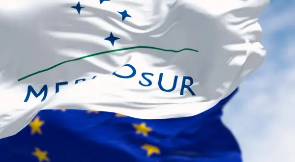 Flaga Mercosur, symbol współpracy gospodarczej, powiewa na tle błękitnego nieba.