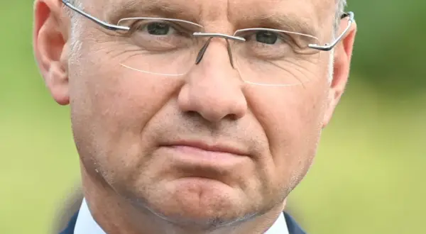 Zbliżenie na twarz mężczyzny w okularach. W jego oczach widać refleksję, jakby zastanawiał się nad przyszłością, może nad swoją emeryturą prezydencką.