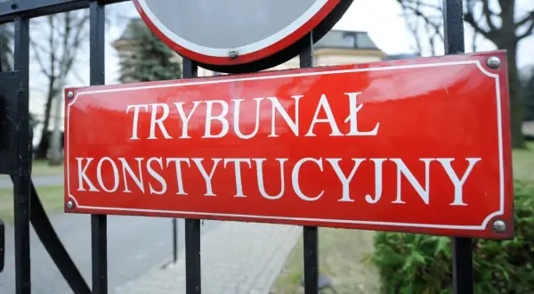Tablica "Trybunał Konstytucyjny" na tle bramy. Symbol zmian w krs i trybunale konstytucyjnym za PIS.