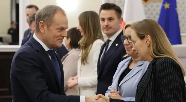 Donald Tusk ściska dłoń, Polska 2050 i Koalicja Obywatelska rywalizują o centrowy elektorat.