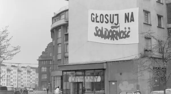 Transparent baner "Głosuj na Solidarność" na budynku, symboliczny protest przeciwko komunizmowi.