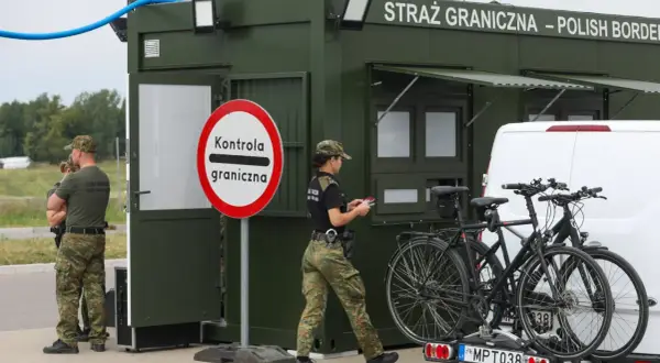 Strażnicy graniczni prowadzą kontrole na granicy niemieckiej. Obok zielonego punktu kontrolnego stoją dwa rowery na bagażniku samochodu.
